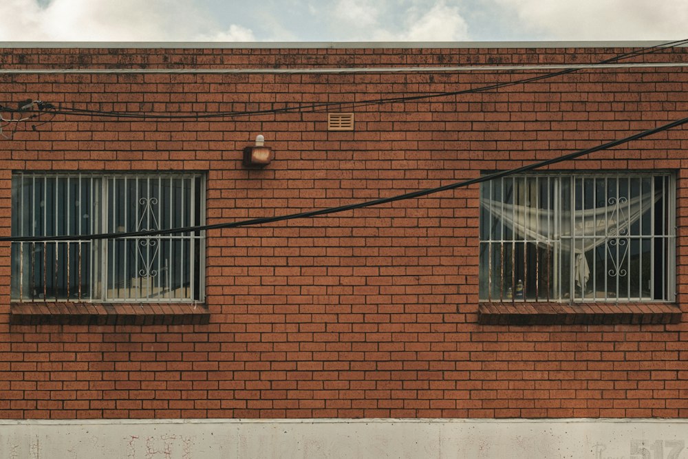 Protecciones de fierro en dos ventanas de una casa de ladrillo en su comuna